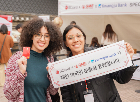 외국인 관광객들이 지난 1일 경기 용인 한국민속촌을 방문해, BC카드 및 광주은행, 글로벌머니익스프레스가 준비한 미니 현수막을 들고 기념촬영을 하고 있다. [BC카드 제공]